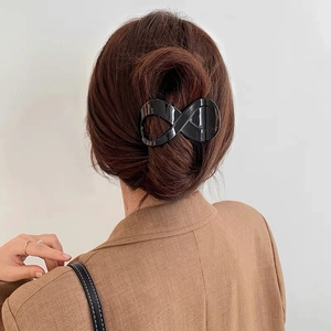 Glossy black infinity hair claw clip holding a bun in dark brown long hair
