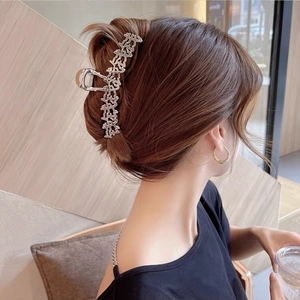 Dettaglio di una grande pinza per capelli argento con caratteri cinesi in uno chignon