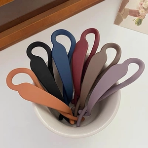 Détail de sept pinces à cheveux banane mates en diverses couleurs unies pour femmes