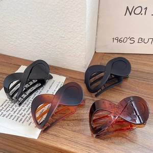 Set of four figure-eight claw clips in matte and glossy black and amber finishes