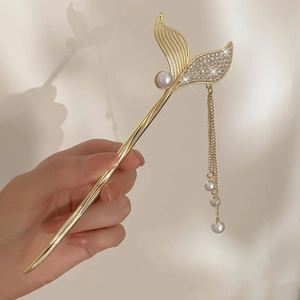Detailed view of mermaid tail hair pin with sparkling crystals and pearl tassels