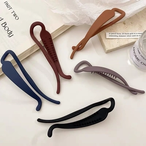 Cinq barrettes banane mates de couleurs variées posées à plat avec détails de peigne intérieur