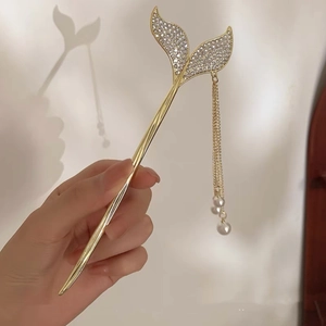 Detailed view of mermaid tail hair pin with dangling pearls and shimmering rhinestones