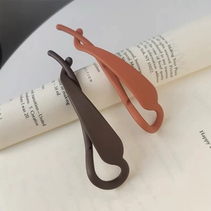 Vue détaillée des barrettes banane minimalistes en résine mate couleur café et terre cuite