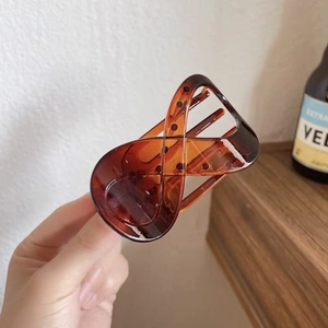 Detail of an amber tortoiseshell hair claw clip with a smooth figure-eight design