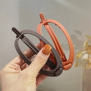 Barrettes ovales mates minimalistes en café et orange corail tenues à la main