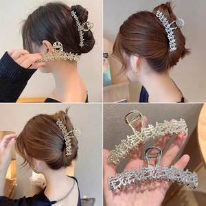 Dettaglio macro di grandi fermagli per capelli in metallo con caratteri cinesi a moneta