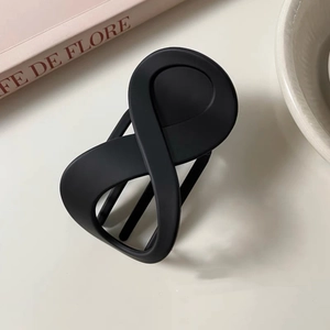 Matte black infinity-shaped hair claw clip with a modern minimalist streamlined design