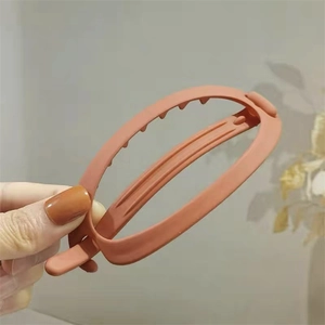 Détail d'une pince à cheveux banane mate terre cuite avec dents intérieures sûres