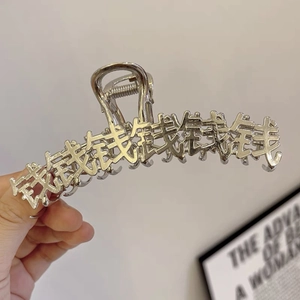 Dettaglio macro della molletta per capelli in metallo argento con caratteri cinesi