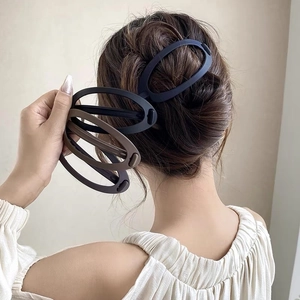 Gros plan de pinces à cheveux ovales mates sur les cheveux, design ergonomique et coloris