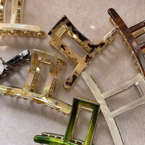 Elegant acetate claw clip in marble and tortoiseshell patterns with metal spring