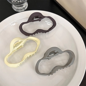 Détails de trois pinces à cheveux mates de forme irrégulière en violet, beige et gris
