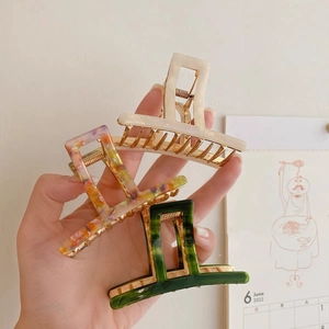 Three-piece acrylic acetate hair claw clips in ivory, marbled, and dark green colors