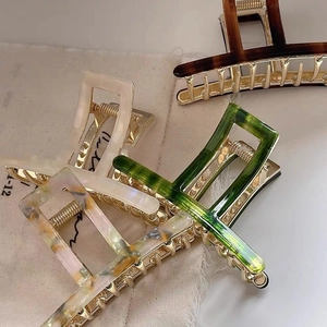 Detail of assorted tortoiseshell and marble acetate hair claws on linen fabric