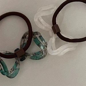 Detail shot of green marble and matte white acetic acid bow hair ties for women