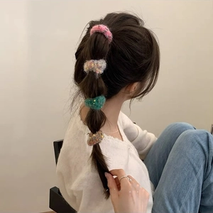 Close-up of four colorful knit hair scrunchies used on a stylish bubble braid hairstyle