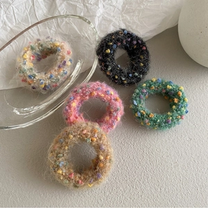 Five assorted colorful tweed-style knitted hair scrunchies in pastel and neutral tones