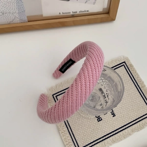 Gros plan détaillé d'un bandeau en maille rose avec texture épaisse et étiquette