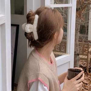 Elegant cream plush shark hair claw clip for women shown on a cozy winter updo