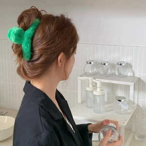 Detail showing plush bright green faux fur hair claw clip for elegant bun hairstyles