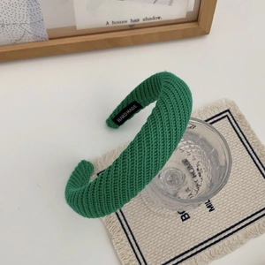 Détail du bandeau en maille verte avec étiquette fait main et texture épaisse côtelée