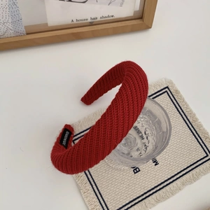 Détail de la texture en maille du bandeau rouge fait main sur un verre décoratif