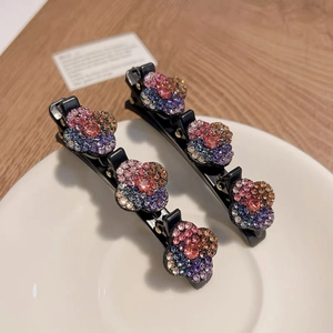 Détail de barrettes à cheveux noires avec décorations florales en strass colorés et brillants