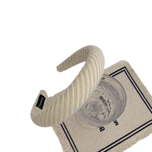 Serre-tête en maille épaisse beige avec étiquette fait main sur support en verre