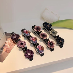 Détail de pinces à cheveux florales avec strass multicolores étincelants sur socle noir