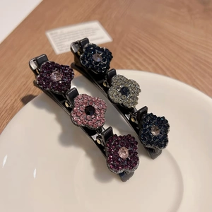 Vue détaillée de barrettes à cheveux fleurs strass sur une assiette en céramique