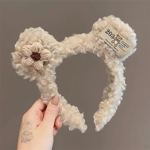 Detail of plush teddy bear ears headband with a woven flower and vintage label