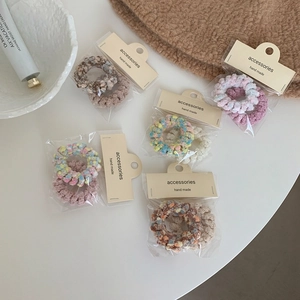 Détail d'élastiques à cheveux spirale en peluche aux couleurs macaron assorties pour femme