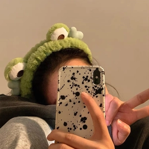 Close-up of soft green plush frog headband with large eyes for washing and makeup