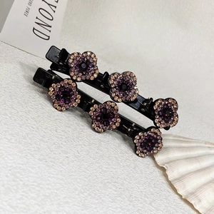 Détail de deux barrettes bec de canard avec strass violets et champagne sur base noire