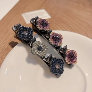 Détail de deux barrettes à cheveux bec de canard ornées de fleurs en strass étincelantes