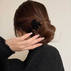 Close-up of black velvet hair claw clip holding a low bun hairstyle for women