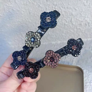 Gros plan de deux pinces à cheveux noires avec fleurs scintillantes et strass colorés