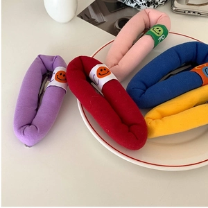 Colorful plush BB hair clips with cute smiley face patterns on white porcelain plate