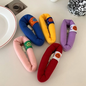 Detailed view of five colorful sponge hair clips with cute smiley face labels in a row