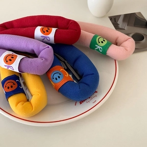 Set of five colorful bubble sponge hair clips with smiley embroidery in a white ceramic dish