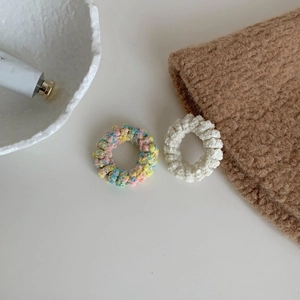 Détail de chouchous en tricot texturé popcorn aux couleurs pastel et blanc crème