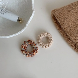 Détail de chouchous en grosse maille faits main aux couleurs crème et automne