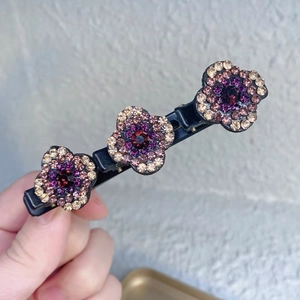Gros plan d'une pince à cheveux florale avec strass violets sur base en alliage