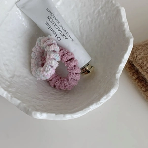 Gros plan d'élastiques en peluche douce rose et bleu dans un bol en céramique