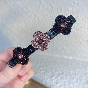 Détail d'une barrette à cheveux avec trois fleurs en cristaux roses et violets