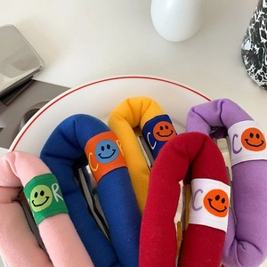 Detail of colorful plush sponge hair clips with smiley face embroidery and soft texture