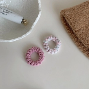 Gros plan sur deux chouchous au crochet faits main en rose et texture tricotée