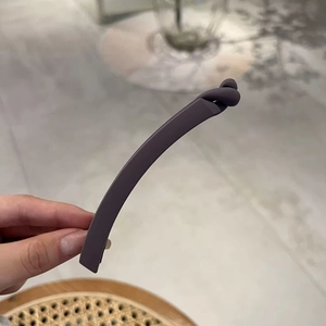 Close-up of matte dark purple-grey banana hair clip with a stylish twist knot design