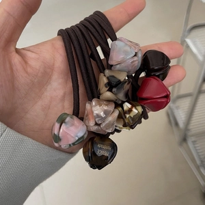 Détail d'élastiques à cheveux faits main avec pendentifs en résine et gravure France